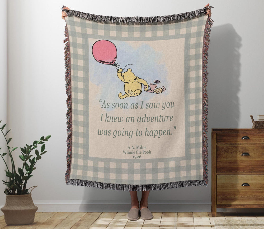 Winnie the Pooh woven throw blanket with Pooh under a red balloon and the adventure quote