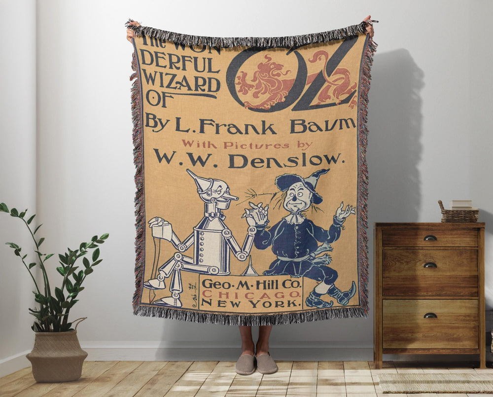 Wizard of Oz woven throw blanket showing the original first edition cover with the Scarecrow and Tin Man