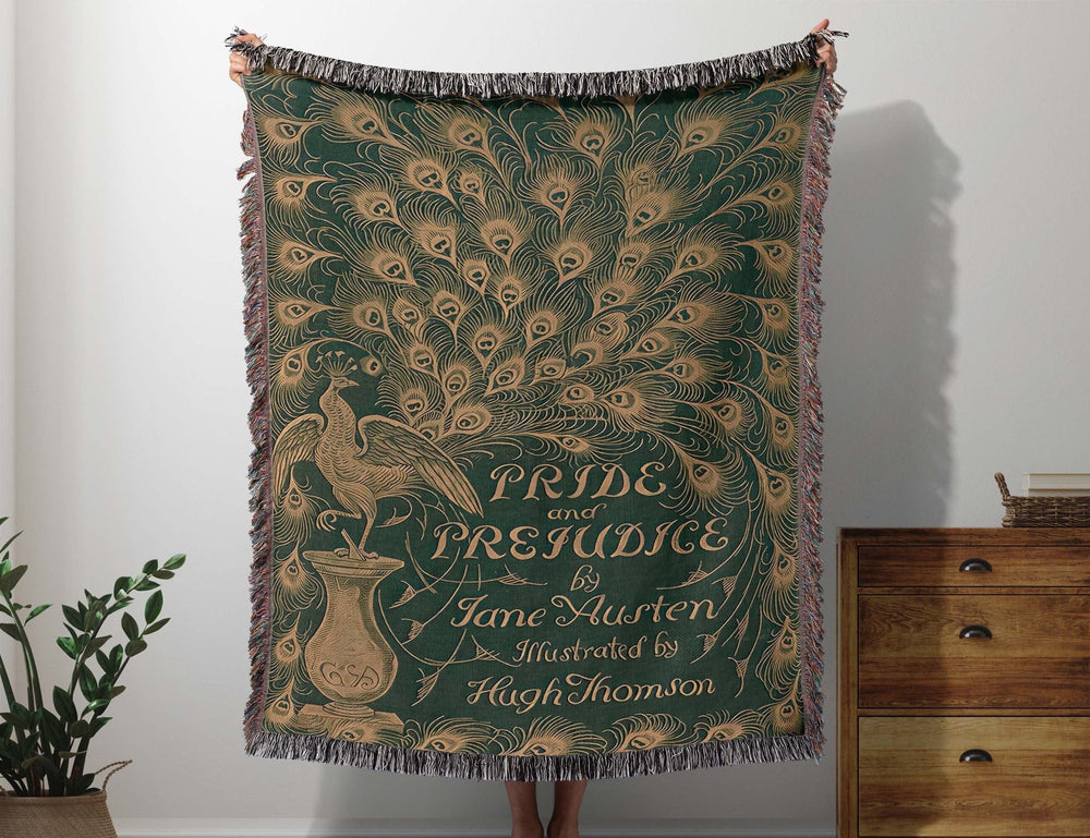 Pride and Prejudice woven throw blanket showing the 1894 Peacock edition cover with Hugh Thomson's peacock design