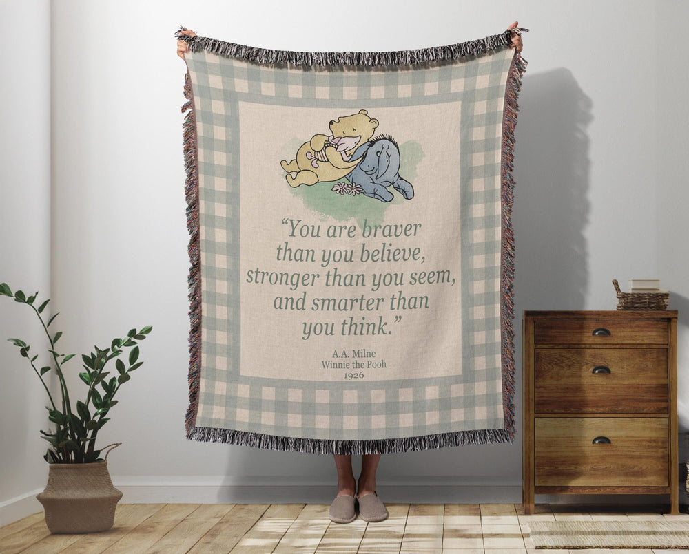 Winnie the Pooh woven throw blanket with the braver than you believe quote and classic Pooh illustration